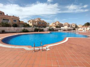 a large blue swimming pool with houses in the background at Casa FLOYD in Caleta De Fuste