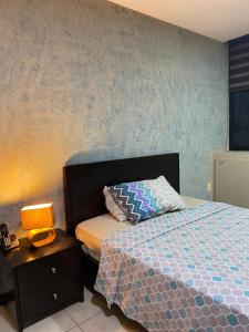 a bedroom with a bed and a lamp on a nightstand at Bellini luxury - Puerto Santa Ana in Guayaquil