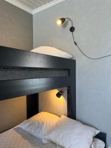 a bedroom with a bed with a black headboard and a lamp at Stuga i centrala Älvdalen in Älvdalen