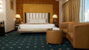 a hotel room with a bed and a couch at Panorama Hotel and Spa in Manama