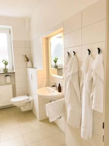 a white bathroom with a sink and a toilet at Altstadt-Wohnung im Weidener Zentrum in Weiden