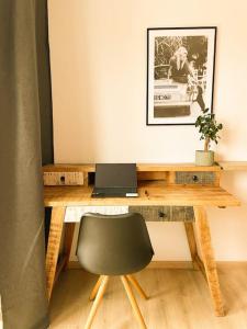 a desk with a laptop and a chair in a room at Altstadt-Wohnung im Weidener Zentrum in Weiden