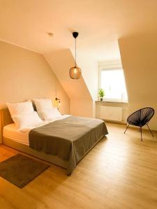 1 dormitorio con 1 cama, 1 silla y 1 ventana en Altstadt-Wohnung im Weidener Zentrum, en Weiden