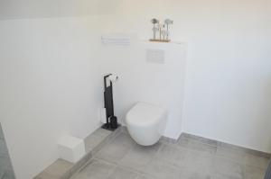 a bathroom with a toilet in a white wall at Pension Lübeck in Lübeck