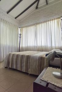 a bedroom with a bed and a table with a lamp at VILLA ALEJANDRA - Hermosa FINCA cerca al centro - Sendero - Jacuzzi in Popayan