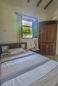 VILLA ALEJANDRA - Hermosa FINCA cerca al centro - Sendero - Jacuzzi في بوبايان: غرفة نوم بسرير كبير ونافذة
