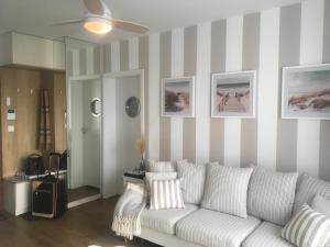 salon z białą kanapą i paskami w obiekcie Apartament Marine Holiday Elbląg - winda -Parking w HALI GARAŻOWEJ -GRATIS -Business stays w Elblągu