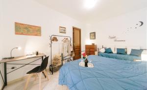 sypialnia z niebieskim łóżkiem i biurkiem w obiekcie Lido Alghero Beach House w mieście Alghero