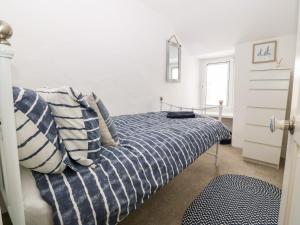 a bedroom with a bed with blue and white pillows at Arwel in Pwllheli