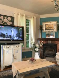 a living room with a tv and a coffee table at Maison de gardien , manoir de Pichemont, » la maison des écureuils » 