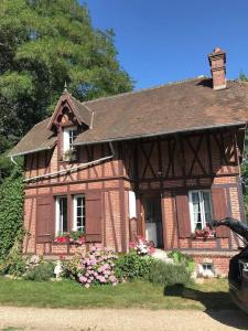 una piccola casa di mattoni con dei fiori di fronte di Maison de gardien , manoir de Pichemont, » la maison des écureuils » 
