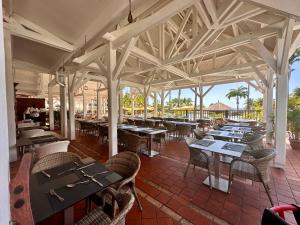 - un coin repas avec des tables, des chaises et un porte-table dans l'établissement Curaçao 13 studio vue mer proche plage dans Complexe type Village Vacances, à Sainte-Luce