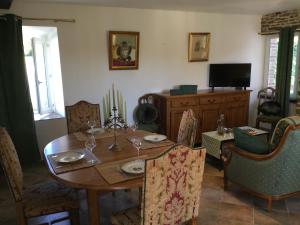 a dining room with a wooden table and chairs at Le cottage normand in Saint-James
