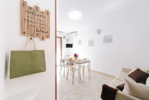 uma sala de estar com uma mesa e um sofá em Lido Alghero Beach House em Alghero