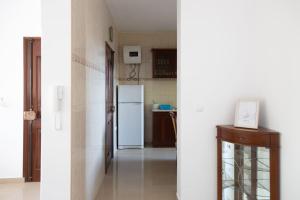 eine Küche mit einem weißen Kühlschrank im Zimmer in der Unterkunft 3 bedroom apt, FREE WIFI & AC, Cidadela - LCGR in Praia