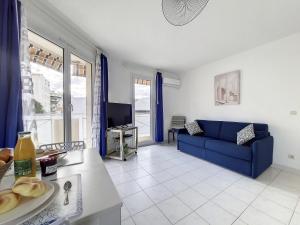 een woonkamer met een blauwe bank en een tv bij Nestor&Jeeves - VANINA - Central - Close sea in Nice
