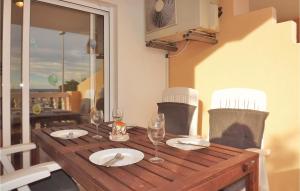 una mesa de madera con vasos y platos. en 2 Bedroom Awesome Apartment In Piles, en Piles