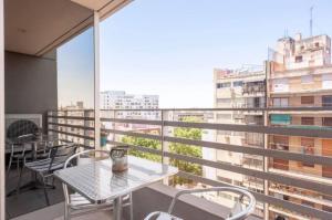a balcony with tables and chairs and a view of a city at Quartier San Telmo Suites 10 in Buenos Aires
