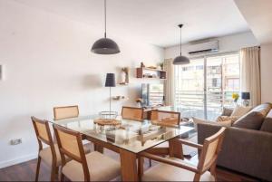 a dining room with a glass table and chairs at Quartier San Telmo Suites 10 in Buenos Aires