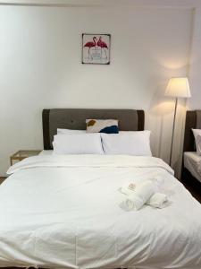a large white bed with two towels on it at Infistay Homestay - Sunway Geo Avenue, Sunway Pyramid, Sunway Lagoon, Sunway University, Sunway Medical Centre in Subang Jaya