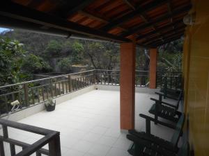 eine Veranda mit 2 Stühlen und einem Balkon in der Unterkunft Pousada do Ceu in Paul