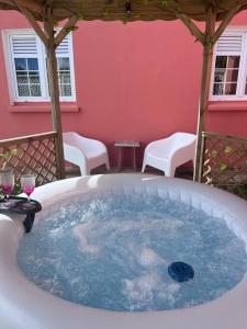 a hot tub on a patio with a table and chairs at Les Tourterelles - Appartement vue mer & jacuzzi in Le Lorrain