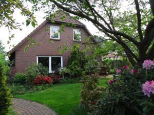 ein Backsteinhaus mit einem Hof mit Blumen in der Unterkunft Hus in de Heiacker, Wohnung 2 in Borkum