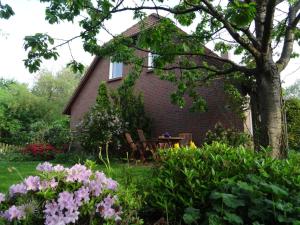 ボルクムにあるHus in de Heiacker, Wohnung 2の庭の花とテーブルのある家