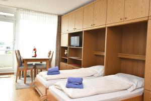 een kamer met drie bedden en een tafel met een raam bij Haus-Seeblick-43 in Borkum