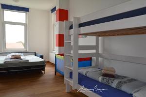 ボルクムにあるVilla-Emilie-Wohnung-Augustineのベッドルーム1室(二段ベッド2台、窓付)が備わります。