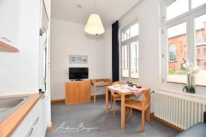 Gaestehaus-St-Josef-1 في بوركوم: مطبخ وغرفة طعام مع طاولة وتلفزيون