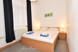 ein Schlafzimmer mit einem Bett mit blauen Handtüchern darauf in der Unterkunft Gästehaus St. Josef 1 in Borkum