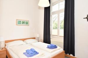 ein Schlafzimmer mit zwei blauen Handtüchern auf einem Bett in der Unterkunft Gästehaus St. Josef 2 in Borkum