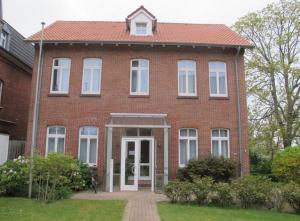 a red brick house with a white door at Gaestehaus-St-Josef-2 in Borkum +5 photos