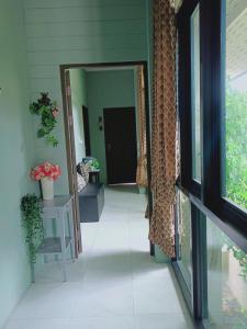 un couloir d'une maison avec une porte ouverte dans l'établissement Sri Ngachang, à Chiang Mai