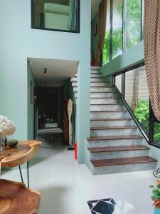 a staircase in a house with a table and a dining room at Sri Ngachang in Chiang Mai