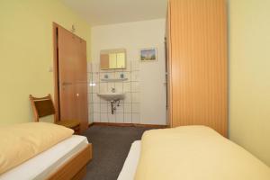 Kleines Zimmer mit 2 Betten und einem Waschbecken in der Unterkunft Haus Bünzow 2 in Borkum