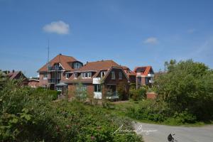 eine Gruppe von Häusern am Straßenrand in der Unterkunft Haus Heizmann in Borkum