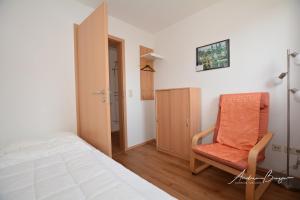 ボルクムにあるGaestehaus-Flandern-4のベッドルーム1室(ベッド1台、椅子付)