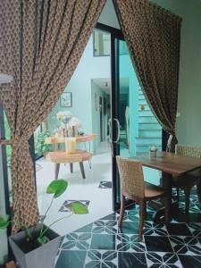 Sri Ngachang في شيانغ ماي: غرفة طعام مع طاولة وكراسي وباب زجاجي