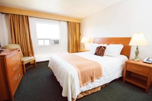 a hotel room with a large bed and a window at Rosslyn Inn & Suites in Edmonton +61 photos