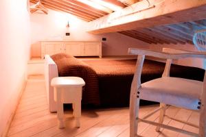 a small bedroom with a bunk bed and a chair at Agriturismo Gualdo Del Re in Suvereto