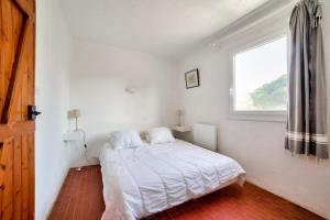 een witte slaapkamer met een bed en een raam bij Maison agreable pour 5 personnes a La Gueriniere in La Guérinière