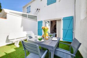 een patio met een tafel en stoelen en een bank bij Maison agreable pour 5 personnes a La Gueriniere in La Guérinière