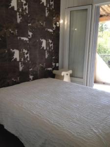 sypialnia z białym łóżkiem i oknem w obiekcie jolie maison piscine privée w mieście Porto-Vecchio