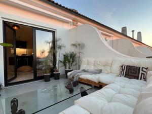 ein Wohnzimmer mit einer weißen Couch und einem Glasboden in der Unterkunft Santa Rita Sunset & Beach Apartment in Maceira