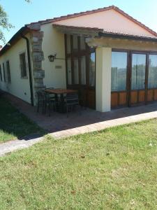 una casa con una mesa y sillas frente a ella en Agriturismo Gualdo Del Re, en Suvereto