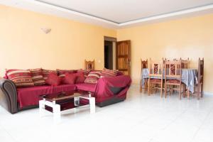 ein Wohnzimmer mit einem roten Sofa und einem Tisch in der Unterkunft 3 bedroom apt, near city center, Assomada - LCGR in Assomada