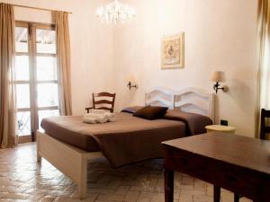 a bedroom with a bed with a chair and a table at Agriturismo Gualdo Del Re in Suvereto