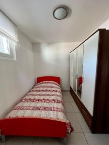 a bedroom with a red bed and a mirror at Appartamento vacanze Sanzen - Como Cernobbio Lugano in Morbio Inferiore